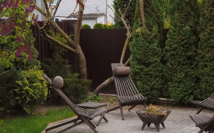Kleine achtertuin met terras, ligstoelen en groene beplanting