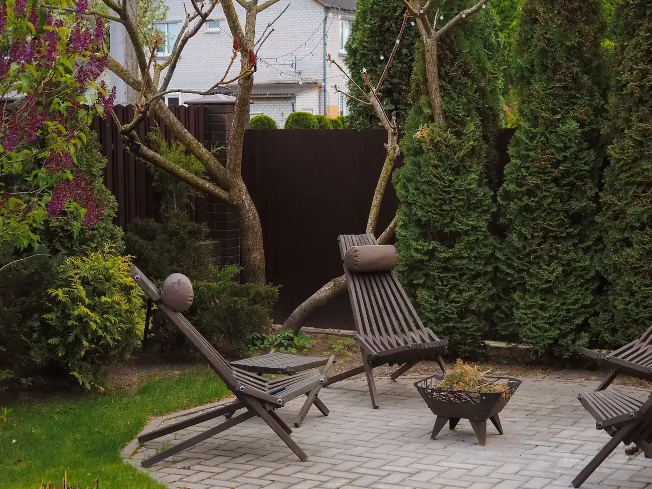 Kleine achtertuin met terras, ligstoelen en groene beplanting