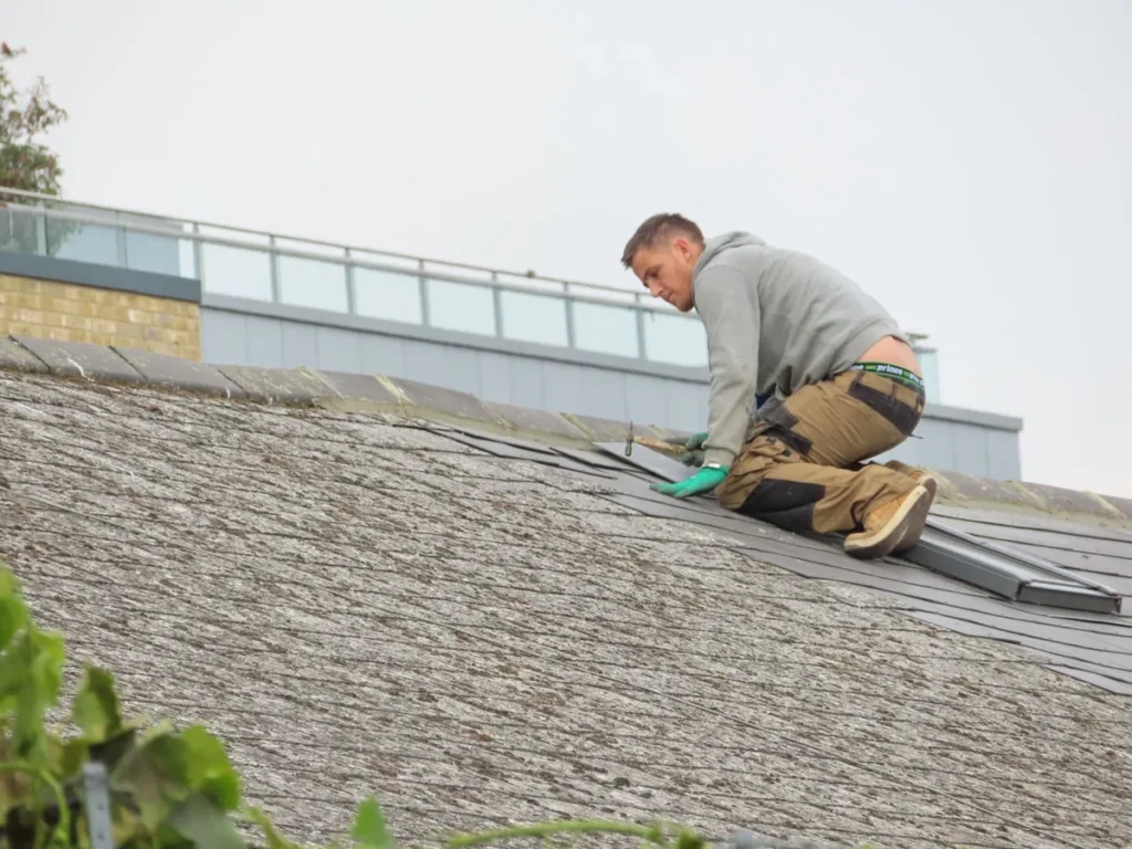 Vakman aan het werk op het dak bij de dakrand