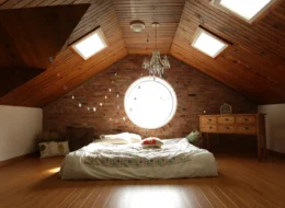 Zolderslaapkamer met dakramen en houten schuine wanden